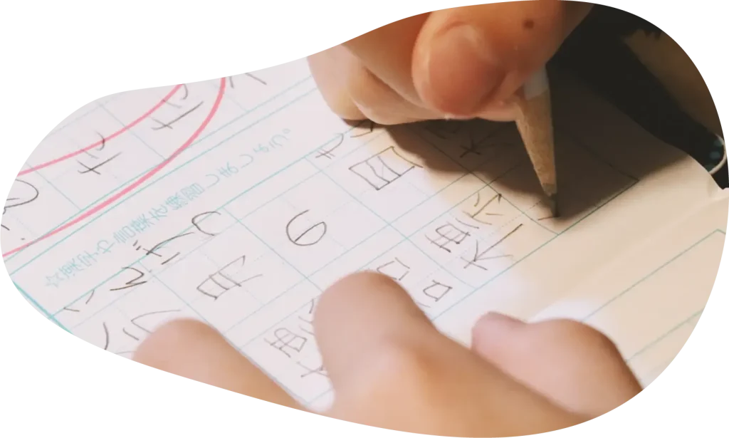 文字を書く子どもの手