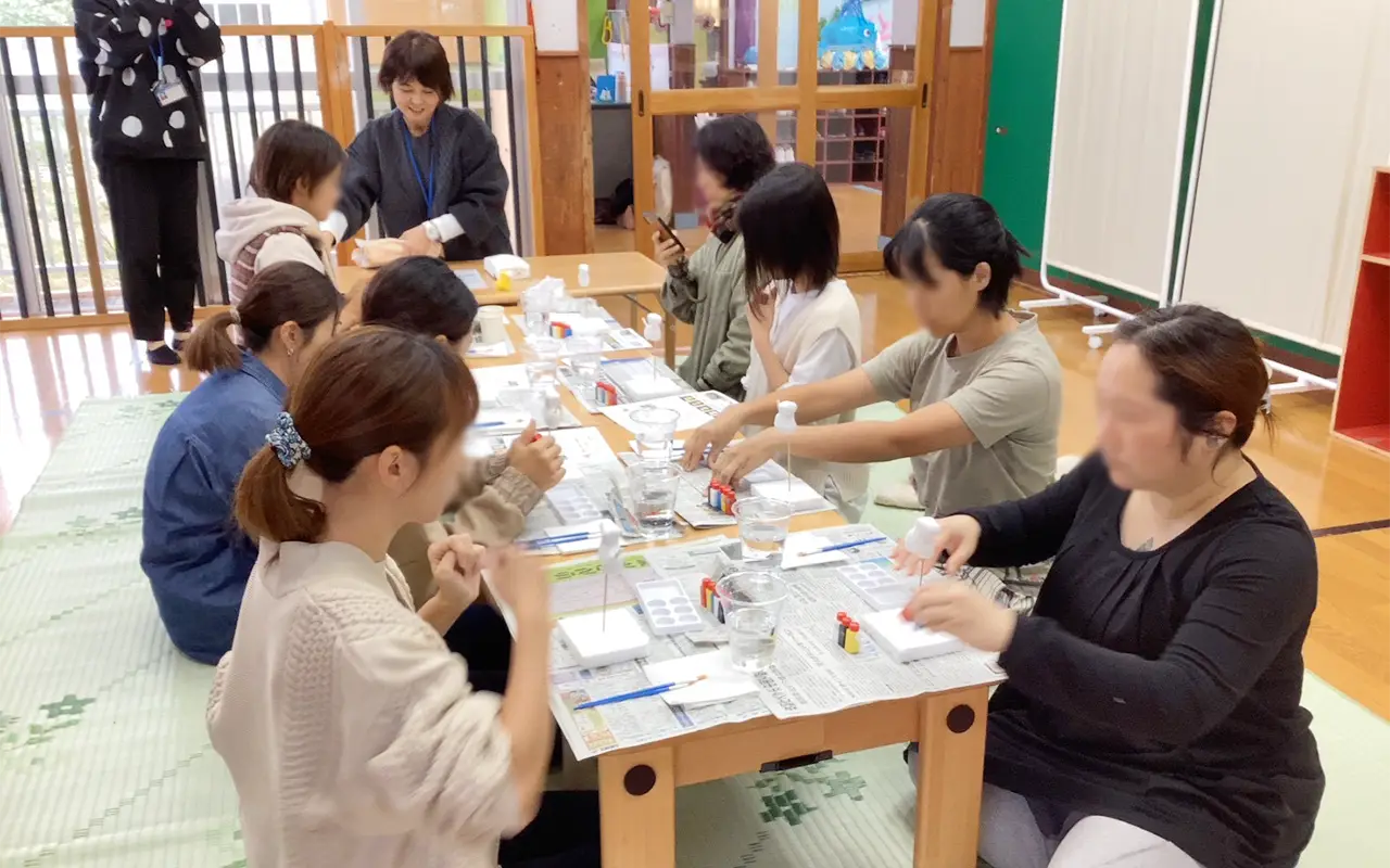 島プロジェクトで保護者といっしょに工作を楽しむ保育士