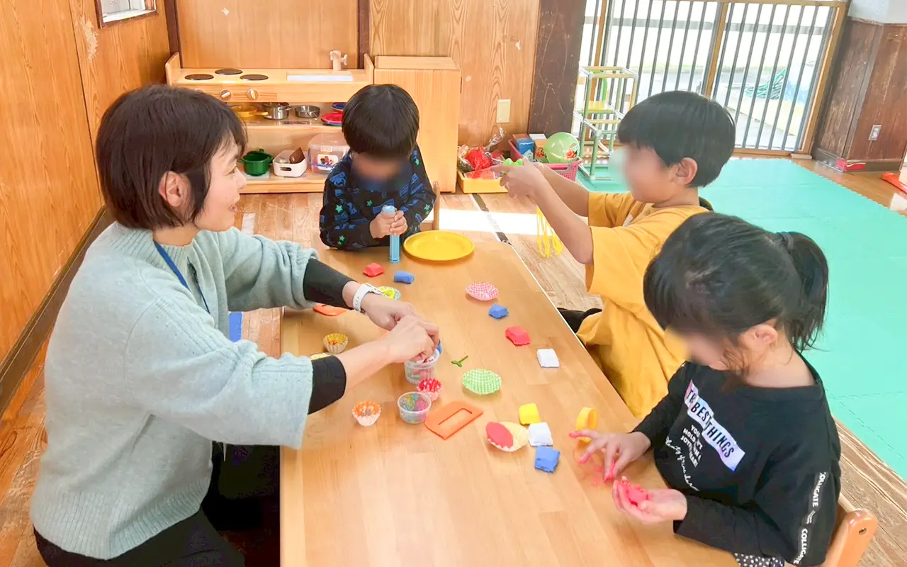 島プロジェクトで子どもと一緒に工作をする保育士