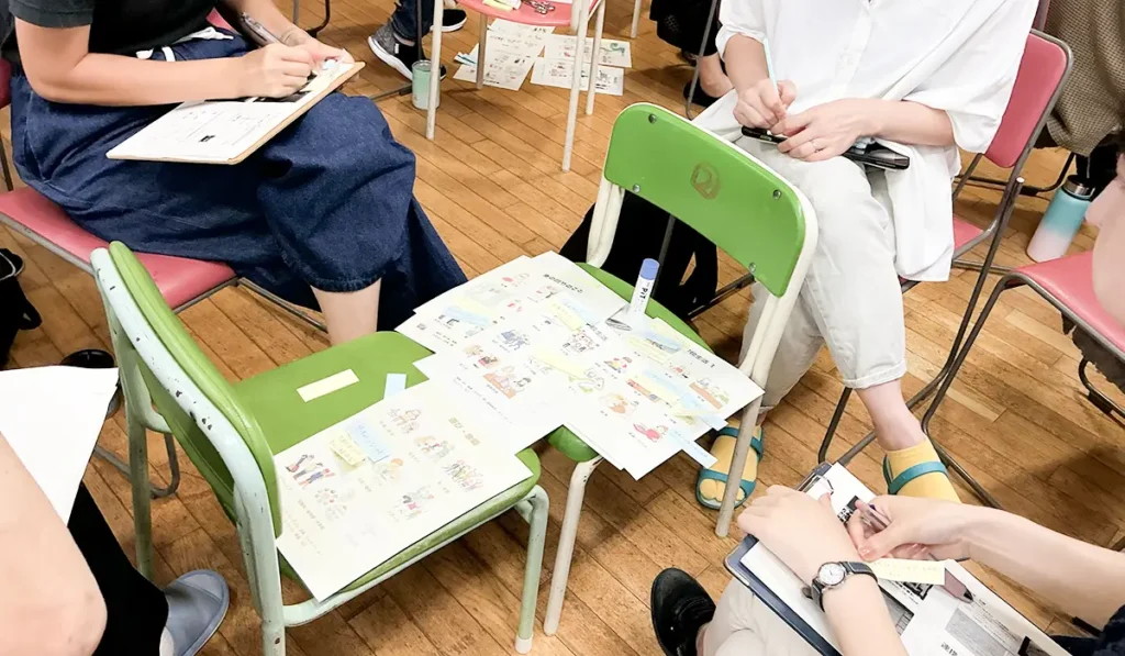 先生役と保護者役に分かれ、付箋を使ってその子に届けたい教育を話し合う、面談の練習場面。