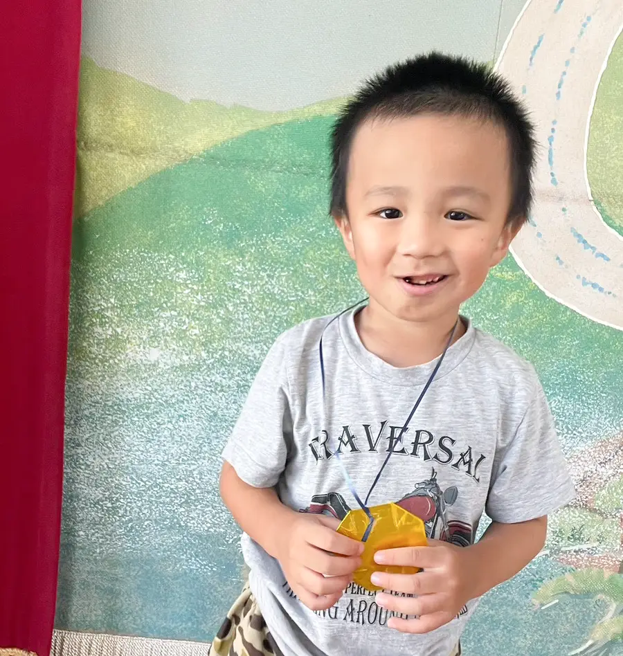 手作りのメダルを首から下げて笑顔を見せる男の子